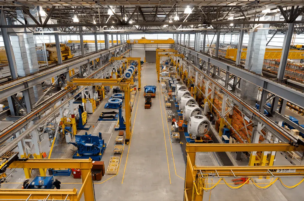 Ampio capannone industriale con linee di produzione e carroponti, dove l'RTLS supporta il monitoraggio della produzione in tempo reale
