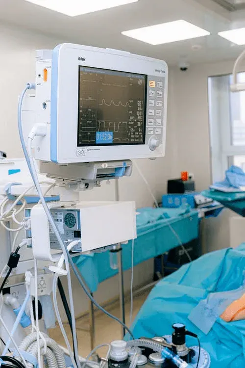 Monitor paziente e ventilatore polmonare accanto a un letto d’ospedale, tipiche attrezzature critiche da localizzare in tempo reale