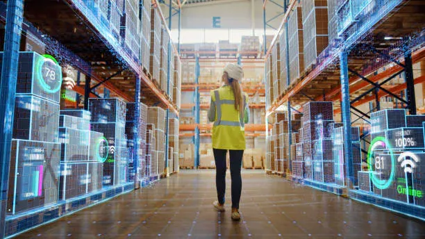 Un magazziniere percorre una corsia con sovrimpressioni digitali sugli scaffali, a illustrare il monitoraggio indoor delle risorse